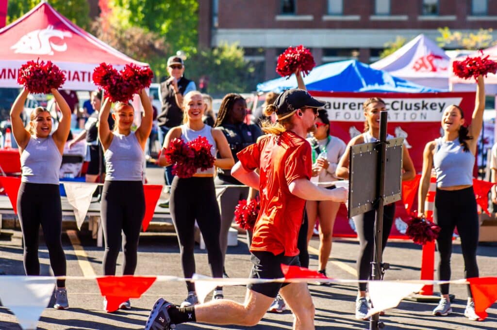 Participant running past Washington State University Cheer team at 2024 Race for Campus Safety